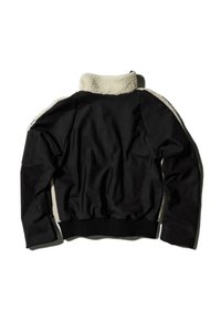 Giacca nera con un morbido colletto in fleece color crema, polsini e vita a costine. Texture esterna liscia con una vestibilità rilassata.