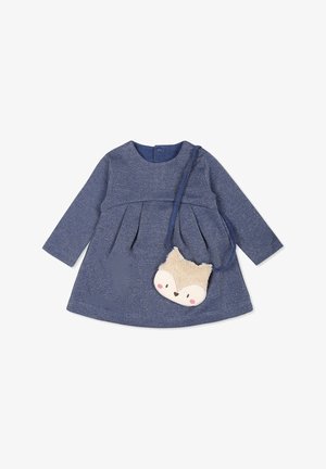 Robe bleu marine à manches longues avec des plis ; encolure ronde ; accompagnée d'un sac en forme de renard beige avec une texture pelucheuse et des détails faciaux.