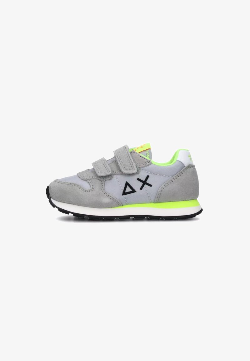 Basket enfant gris et vert néon avec deux bandes velcro, logo géométrique noir sur le côté et semelle blanche avec crampons noirs.