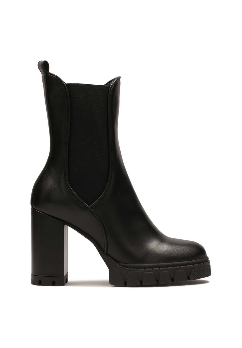 Black ankle boot made of leather with a chunky, textured heel and elastic side panels for easy wear. Includes a rubber sole for grip.