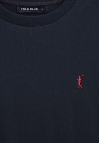Maglietta blu navy con scollo a girocollo e logo ricamato di un giocatore di polo rosso sul petto, con etichetta nera "Polo Club" all'interno del colletto.