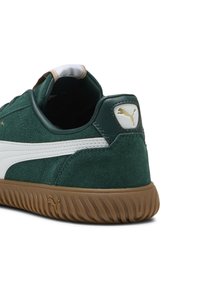 Baskets en daim vert avec une bande en cuir blanc, une semelle en caoutchouc beige et un logo doré sur le talon. Col rembourré pour plus de confort.