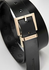 Zwarte leren riem met een rechthoekige gouden metalen gesp met branding. De binnenkant toont gegraveerde details en stiksels.