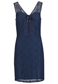 Robe sans manches en dentelle bleu marine avec des motifs circulaires, décolleté en V, détail noué à l'avant, et silhouette ajustée longueur genou.