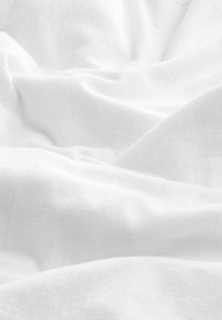Tessuto bianco con una morbida texture, caratterizzato da leggere pieghe e un delicato motivo tessuto. Il materiale appare traspirante e liscio.