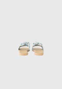 Blue fabric slides with frayed straps, open toe design, flat tan sole, and smooth texture; lightweight casual footwear.