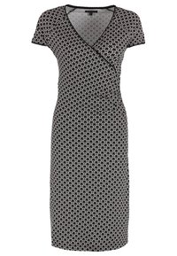 Robe portefeuille à motifs noir et blanc avec des manches courtes, décolleté en V, coupe longueur genoux, présentant un design géométrique et une texture de tissu douce.