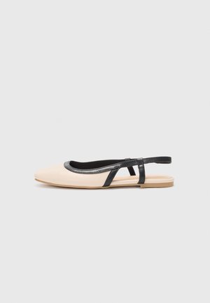 Beżowy płaski but typu slingback z czarną lamówką i paskiem, z ostrym noskiem i niską podeszwą na jasnoszarym tle.