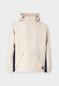 Light beige pullover jacket with a front pocket, navy side panels, and pink snap buttons; includes a drawstring hood and elastic cuffs.