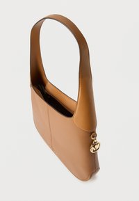 Bolso de hombro de cuero marrón con una correa ancha, cierre superior de cremallera y un colgante de logo redondo dorado en el lateral.