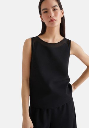 Top nero senza maniche con scollatura rotonda e dettagli in trasparente. Tessuto morbido e vestibilità comoda. Adatto per abbigliamento casual o formale.