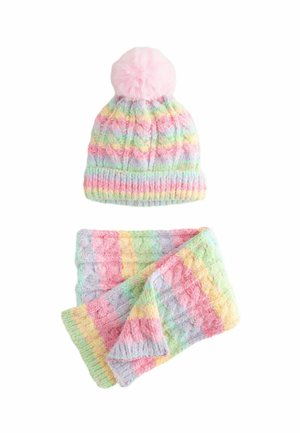 Căciulă tricotată cu dungi pastelate și pompon roz, împreună cu o fular asortat, accesorii de iarnă cu textură moale, așezate pe un fundal alb.