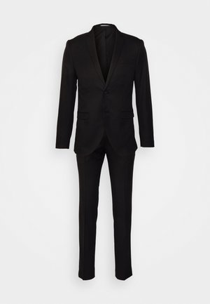 Must mustriga meeste ülikond, millel on ühe nööbiga bleiser ja sobivad slim-fit püksid, valgel taustal.