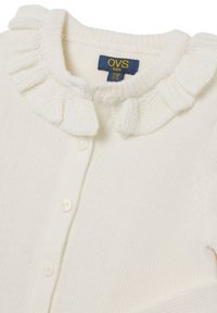 Cardigan de punto en color crema para bebés, con cuello rizado y botones frontales, etiquetado para niños de 4 a 5 años.