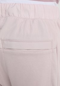 Rosa bomullsjoggers med elastisk midja, med en bakficka säkrad med ett rektangulärt lock och subtil textur.