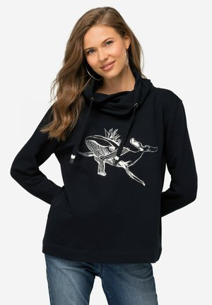 Haut à capuche noir avec un col cheminé, orné d'un design graphique blanc représentant un poisson et des formes abstraites, fabriqué en tissu doux en mélange de coton.