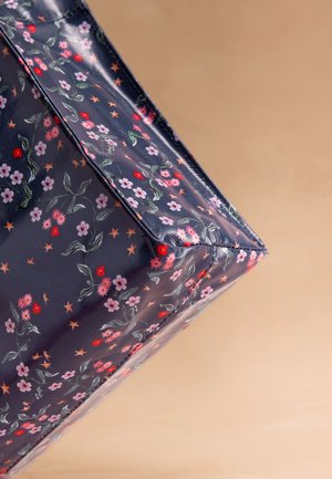 Tumši zila taisnstūrveida soma ar rozā, sarkanu un violetu ziedu un zvaigžņu rakstu uz bēša fona.