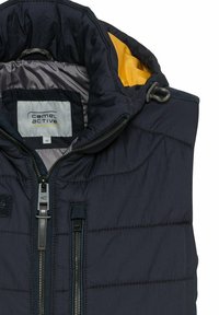 Navy prošívaná vesta s žlutou podšívkou, obsahující přední zipy, detaily šití a logo na límci. Velikost 48.