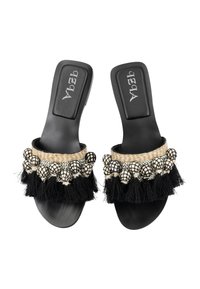 Fekete csúszó szandál széles pánttal, texturált fekete bojtokkal, bézs szőtt részletekkel és díszes fekete-fehér pom-pomokkal.