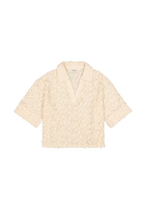 Chemisier à manches courtes en dentelle couleur blanc cassé, avec un col à revers, un motif floral et une coupe ample aux bords effilochés.