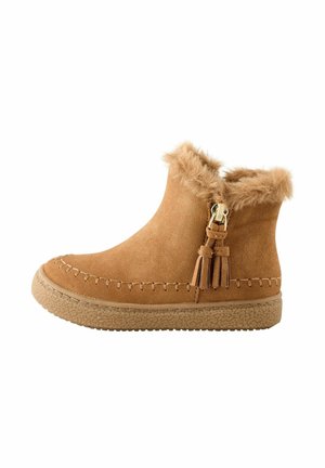 Stivali alla caviglia in suede color cammello, con bordo in finta pelliccia, un tassello decorativo con hardware e una suola in gomma testurizzata. Dettagli cuciti lungo il bordo.