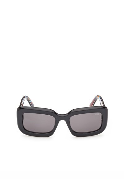 Gafas de sol rectangulares negras con montura gruesa y lentes oscuras, con una sutil marca en la esquina superior de una de las lentes.