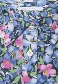 Blumenhemd mit einer Mischung aus blauen und rosa Blumen auf einem dunklen Hintergrund, mit spitzem Kragen, regulärer Passform und weißen Knöpfen.