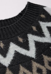Svart stickad tröja med ribbat halslinning, prydd med ett geometriskt mönster i ljusgrått och beige, vilket ger en strukturerad look.