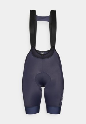 Mornarice kolesarske hlače s podloženim hlačnicami, črnimi naramnicami, podloženo blazinico in brezšivnim zaključkom. Imajo logotip na strani in tesen kroj.