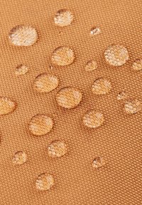 Gouttes d'eau reposant sur un tissu brun texturé, démontrant des propriétés de surface résistantes à l'eau.