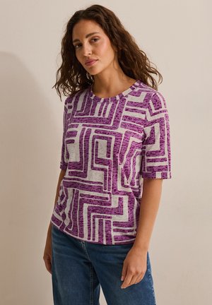 Kortærmet lila mønstret t-shirt med geometriske hvide linjer, med rund halsudskæring og en afslappet pasform, lavet af let stof.