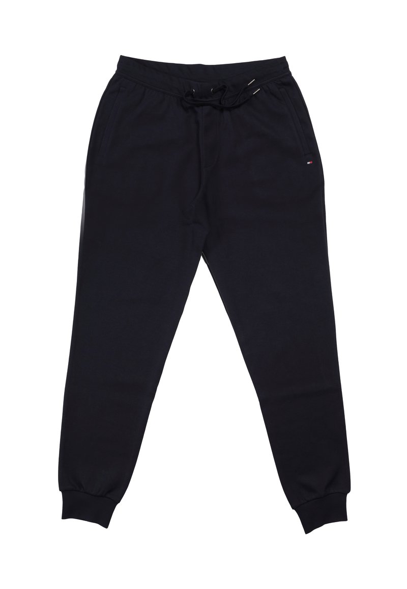 Donkerblauwe trainingsbroek gemaakt van zachte stof, voorzien van een elastische tailleband met trekkoord, zijzakken en geribbelde boorden bij de enkels.