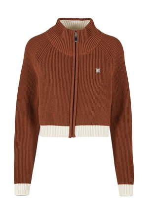 Pull zippé raccourci en rouille avec texture côtelée. Présente un col haut et un ourlet côtelé blanc. Petit emblème de la marque sur la poitrine.