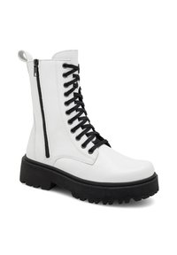 Baltas sintētiskās ādas kaujas zābaks ar melnām auklām un sānu rāvējslēdzēju. Iespējas ietver masīvu melnu gumijas zoli ar protektoru, kas nodrošina saķeri.