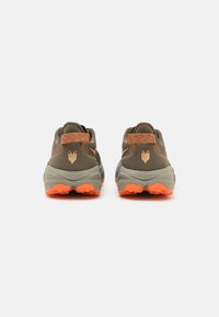 Outdoor shoes featuring a dark olive upper, orange accents, and a textured sole for grip. Notable back logo and ankle support design.