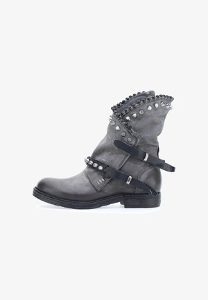 Grijze leren enkellaars met een gestructureerde bovenkant, decoratieve studs en banden. Rondneus en gestapelde hak. Accenten langs de kraag.
