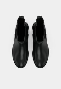 Crne kožne čizme do gležnja s glatkom završnom obradom, elastičnim bočnim panelima i zaobljenim vrhom. Pojednostavljeni dizajn, minimalna oprema i čiste linije.