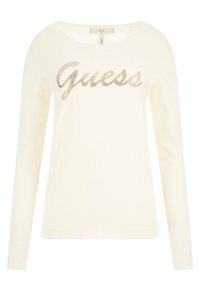 Pull crème à manches longues avec encolure ronde, poignets et ourlet côtelés, arborant le logo "Guess" en lettres de strass dorés sur la poitrine.