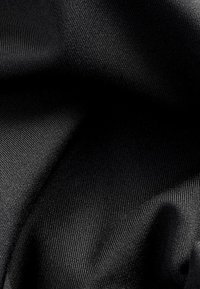 Black fabric with a smooth, textured surface, exhibiting fine ribbing and subtle sheen. Material appears lightweight and flexible.