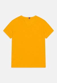 Żółta krótki rękaw t-shirt wykonany z bawełny, z okrągłym dekoltem i małym pionowym detalem na plecach przy szyi.