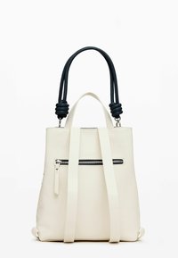 Bolso de imitación de cuero blanco con asas negras, que cuenta con un bolsillo frontal con cremallera, correas planas y una forma rectangular estructurada.
