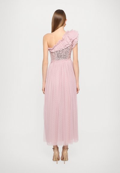 Ein einseitig schulterfreies pinkes Kleid mit Rüschendetails, tailliertem Oberteil mit strukturierten Akzenten und einem bodenlangen, gefältelten Tüllrock mit Punkte-Muster.