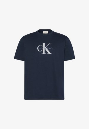 Tengerészkék pamut póló kerek nyakkivágással, rövid ujjakkal, és elöl egy könnyen látható világosszürke Calvin Klein logóval, amely "ck" mintát ábrázol.