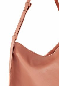 Bolso de hombro de cuero rosa con un acabado suave, apertura amplia y correa ajustable con acentos de hardware metálico.