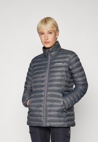 Gray puffer jacket with a high collar, horizontal quilted design, zip closure, and logo accent on the chest. Features side pockets.