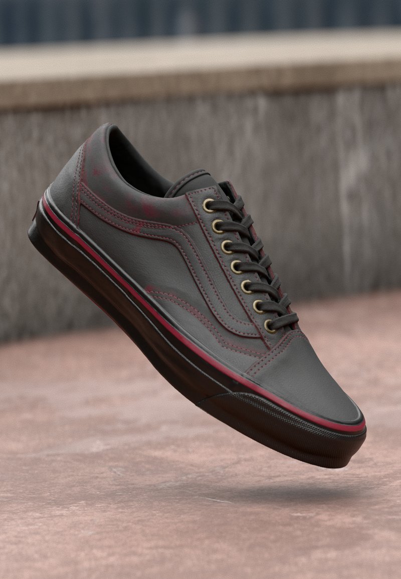 Sneaker en cuir gris avec un bout arrondi, semelle noire, accents rouges et œillets dorés. Dispose d'un dessus texturé et d'un design classique à lacets.