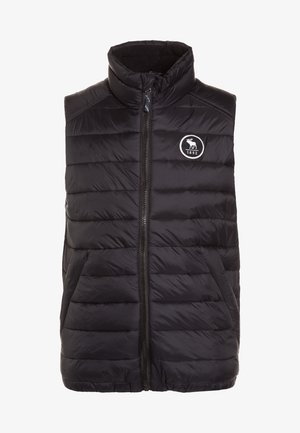 Czarna pikowana kamizelka z wysokim kołnierzem, zapinana na zamek błyskawiczny z przodu, z pionowym wzorem pikowania. Posiada okrągłe logo z łosiem i rokiem 1892.