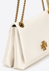 Bílá kožená kabelka se strukturovaným designem, která má zlatý logo hardwaru a řetězové detaily na popruhu. Texturovaný povrch a lesklé detaily.
