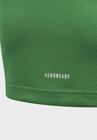 Zelený sportovní top z elastické tkaniny s texturovaným povrchem. Logo "AEROREADY" v bílé barvě je umístěno blízko spodního okraje.