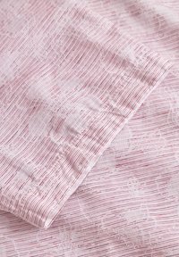 Tessuto rosa chiaro con un sottile motivo a righe e una texture floreale, caratterizzato da linee verticali in toni di rosa più scuri. Materiale morbido e leggero.